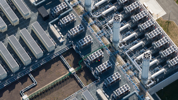 Aerial view of an industrial facility featuring cooling towers complex piping systems and technical equipment in Dietzenbach Hessen Germany. Aerial view of an industrial facility featuring cooling towers complex piping systems and technical equipment in Dietzenbach Hessen Germany.
