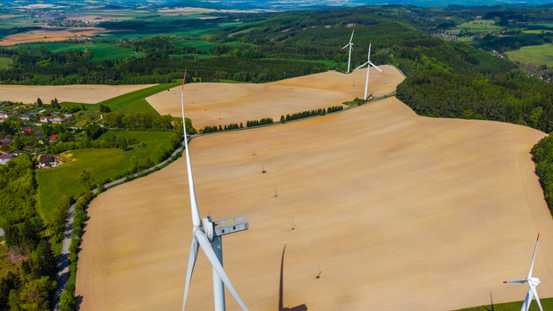 Aerial view of the Zipotin wind turbines standing in vast agricultural fields surrounded by lush green forests and rolling hills in Gruna Pardubicky kraj Czechia. Aerial view of the Zipotin wind turbines standing in vast agricultural fields surrounded by lush green forests and rolling hills in Gruna Pardubicky kraj Czechia.
