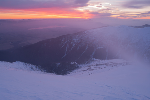 View of Baranec peak in the Western Tatras during a windy winter sunrise with snow covered slopes and a vibrant pink sky in Jamnik Zilina Region Slovakia. View of Baranec peak in the Western Tatras during a windy winter sunrise with snow covered slopes and a vibrant pink sky in Jamnik Zilina Region Slovakia.