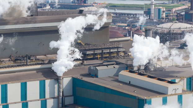 Aerial view of the Tata Steel industrial plant with thick white smoke rising from chimneys and cooling systems in Velsen Noord Noord Holland Netherlands. Aerial view of the Tata Steel industrial plant with thick white smoke rising from chimneys and cooling systems in Velsen Noord Noord Holland Netherlands.