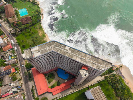 Aerial view of a modern hotel complex with swimming pools and lush green lawns along the crashing waves of the Indian Ocean in Galle Southern Province Sri Lanka. Aerial view of a modern hotel complex with swimming pools and lush green lawns along the crashing waves of the Indian Ocean in Galle Southern Province Sri Lanka.