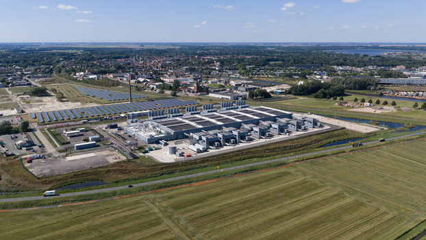 Aerial view of the HGB data center facility featuring large industrial buildings rows of solar panels and surrounding agricultural fields in Winschoten Groningen Netherlands.