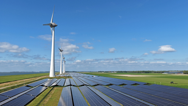 Aerial view of wind turbines and a large solar panel array in a flat green landscape in Rutten Flevoland Netherlands. Aerial view of wind turbines and a large solar panel array in a flat green landscape in Rutten Flevoland Netherlands.