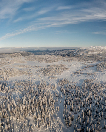Aerial view of Gaustablikk Fjellresort surrounded by snow covered pine forests and mountains under a clear blue sky in Rjukan Telemark Norway. Aerial view of Gaustablikk Fjellresort surrounded by snow covered pine forests and mountains under a clear blue sky in Rjukan Telemark Norway.