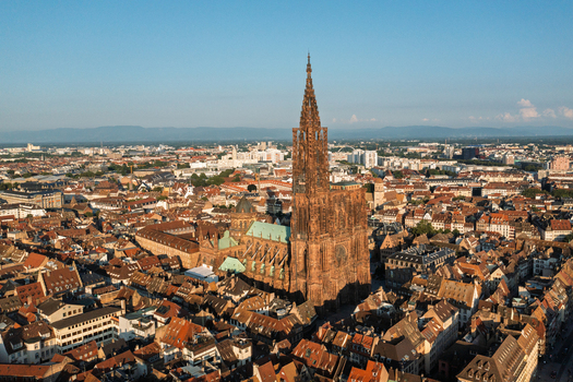 Aerial view of Cathedrale Notre Dame de Strasbourg surrounded by historic rooftops and urban landscape in Strasbourg Grand Est France.