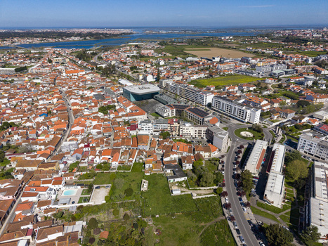 Aerial view of terracotta rooftops contrasting with modern architecture overlooked by distant waterways Vila Nova de Gaia Portugal. Aerial view of terracotta rooftops contrasting with modern architecture overlooked by distant waterways Vila Nova de Gaia Portugal.