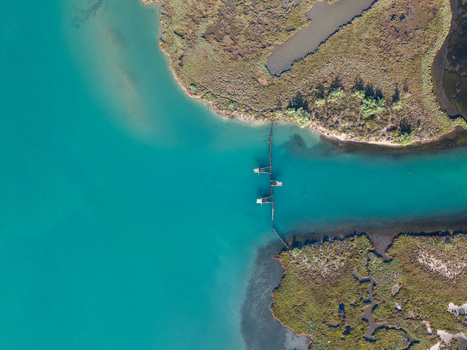 Aerial view of the turquoise waters of Kanali i Vivarit with traditional fishing traps and marshy banks in Vrine Vlore County Albania. Aerial view of the turquoise waters of Kanali i Vivarit with traditional fishing traps and marshy banks in Vrine Vlore County Albania.