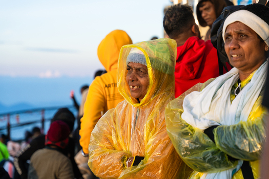 Ratnapura Sri Lanka 23 February 2026 View of pilgrims wearing yellow rain ponchos while waiting at the summit of Adam s Peak during the early morning hours.