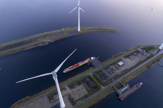 Aerial view of the Krammer locks featuring wind turbines and a cargo ship navigating the canal in Bruinisse Zeeland Netherlands. Aerial view of the Krammer locks featuring wind turbines and a cargo ship navigating the canal in Bruinisse Zeeland Netherlands.