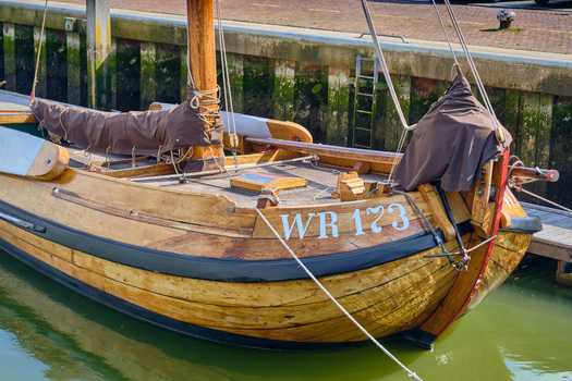 Den Oever Netherlands 18 May 2026 View of historic wooden sailing vessel of the type Wieringeraak docked in the fishing harbor with its mast and rigging visible. Den Oever Netherlands 18 May 2026 View of historic wooden sailing vessel of the type Wieringeraak docked in the fishing harbor with its mast and rigging visible.