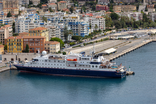 Aerial view of a cruise ship docked at the Port of Nice with urban buildings and coastal infrastructure in Nice Provence Alpes Cote d Azur France. Aerial view of a cruise ship docked at the Port of Nice with urban buildings and coastal infrastructure in Nice Provence Alpes Cote d Azur France.