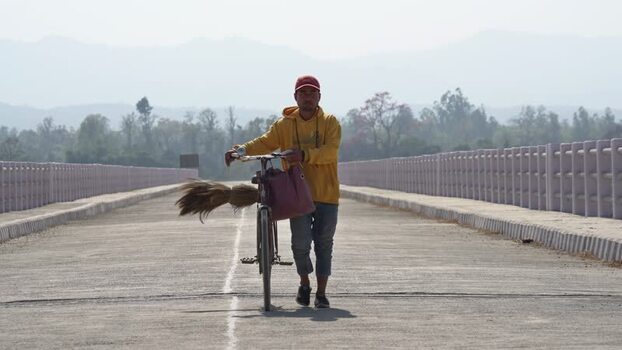 View of a man walking with a bicycle on a bridge Nepal. View of a man walking with a bicycle on a bridge Nepal.