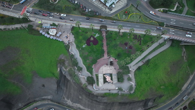 Aerial view of Love Park featuring the iconic El Beso sculpture lush green lawns and winding pathways situated along the coastal cliffs in Miraflores Provincia de Lima Peru. Aerial view of Love Park featuring the iconic El Beso sculpture lush green lawns and winding pathways situated along the coastal cliffs in Miraflores Provincia de Lima Peru.