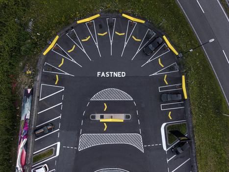 Aerial view of a Fastned electric vehicle charging station with yellow parking markings and parked cars in Amsterdam Noord Holland Netherlands. Aerial view of a Fastned electric vehicle charging station with yellow parking markings and parked cars in Amsterdam Noord Holland Netherlands.