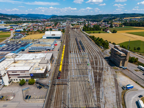 Aerial view of Daniken train station with multiple railway tracks industrial buildings and surrounding fields in Daniken Solothurn Switzerland.