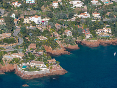 Aerial view of Le Trayas featuring luxury villas nestled among red rocky cliffs overlooking the Mediterranean Sea in Saint Raphael Provence Alpes Cote d Azur France. Aerial view of Le Trayas featuring luxury villas nestled among red rocky cliffs overlooking the Mediterranean Sea in Saint Raphael Provence Alpes Cote d Azur France.