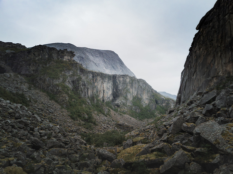 Aerial view of the dramatic Hellemojuvet canyon featuring steep rock walls rugged boulder strewn slopes and sparse vegetation under an overcast sky in Hellmobotn Nordland Norway. Aerial view of the dramatic Hellemojuvet canyon featuring steep rock walls rugged boulder strewn slopes and sparse vegetation under an overcast sky in Hellmobotn Nordland Norway.