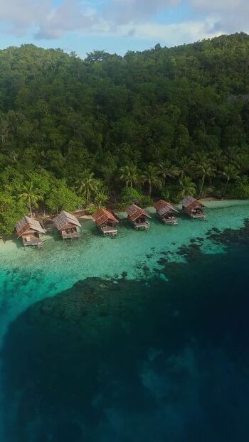 Aerial view of overwater bungalows in Fam Islands Indonesia.