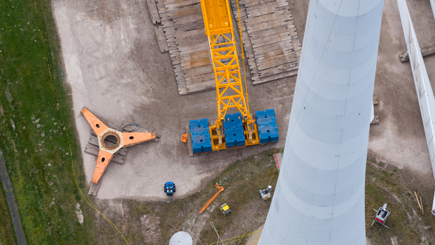 Aerial view of wind turbine construction site with a large yellow crane blue counterweights and turbine components on the ground in Espel Flevoland Netherlands. Aerial view of wind turbine construction site with a large yellow crane blue counterweights and turbine components on the ground in Espel Flevoland Netherlands.