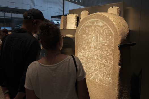 Giza Egypt 16 May 2026 View of people looking at an ancient stone stele with hieroglyphics inside the Grand Egyptian Museum.