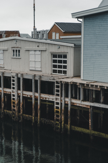 View of traditional wooden fishing huts on stilts over the water in Henningsvaer Nordland Norway. View of traditional wooden fishing huts on stilts over the water in Henningsvaer Nordland Norway.