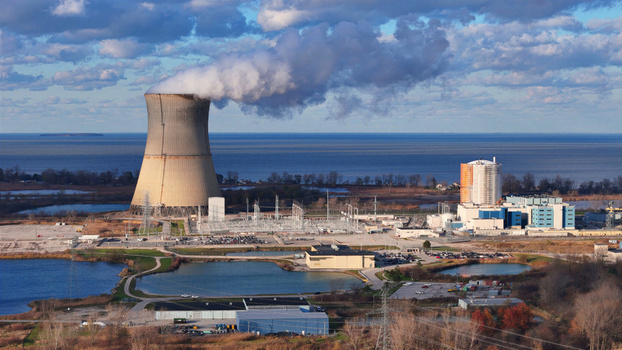 Aerial view of Davis Besse Nuclear Power Station with cooling tower power plant facilities electrical substation and ponds along Lake Erie in Oak Harbor Ohio United States.