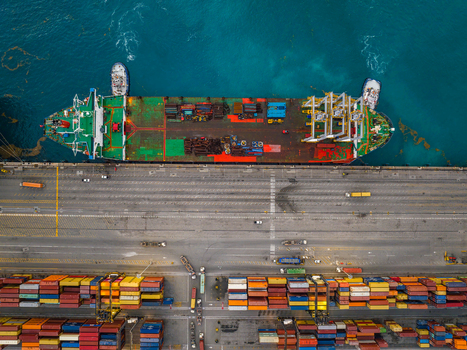 Aerial view of the Caucedo Logistics Center in Andres Santo Domingo Dominican Republic featuring a large cargo ship docked at the pier alongside rows of colorful shipping containers. Aerial view of the Caucedo Logistics Center in Andres Santo Domingo Dominican Republic featuring a large cargo ship docked at the pier alongside rows of colorful shipping containers.