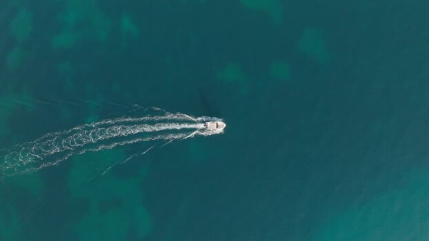 Aerial view of a boat cruising in turquoise water Italy. Aerial view of a boat cruising in turquoise water Italy.
