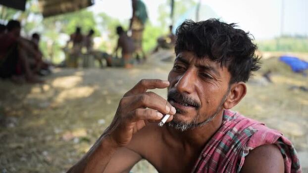 View of a man smoking a cigarette in Natore Bangladesh. View of a man smoking a cigarette in Natore Bangladesh.
