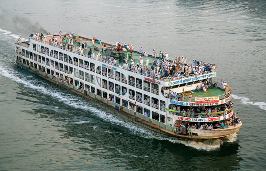 Munshiganj Bangladesh 04 April 2026 Aerial view of a bustling ferry cutting through the murky river its decks teeming with passengers under the open sky. Munshiganj Bangladesh 04 April 2026 Aerial view of a bustling ferry cutting through the murky river its decks teeming with passengers under the open sky.