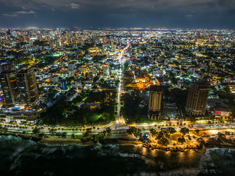 Aerial view of the illuminated Santo Domingo Malecon coastline with city lights skyscrapers and the Caribbean Sea at night in Santo Domingo Distrito Nacional Dominican Republic. Aerial view of the illuminated Santo Domingo Malecon coastline with city lights skyscrapers and the Caribbean Sea at night in Santo Domingo Distrito Nacional Dominican Republic.