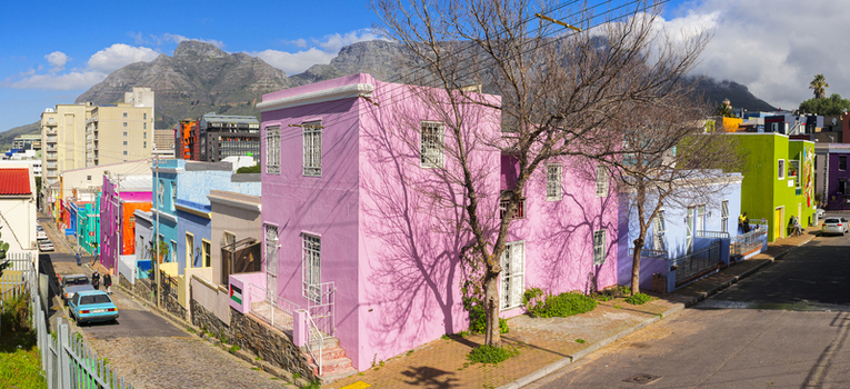 View of the vibrant and colorful houses of the Bo Kaap neighborhood with Table Mountain under a blue sky in Cape Town Western Cape South Africa. View of the vibrant and colorful houses of the Bo Kaap neighborhood with Table Mountain under a blue sky in Cape Town Western Cape South Africa.