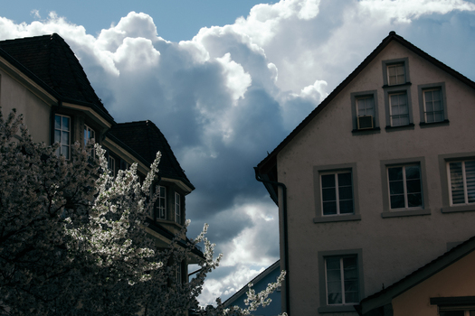 Zurich Switzerland 02 April 2023 View of traditional architecture meeting a vibrant sky where the stark white buildings are juxtaposed against the billowing storm clouds. Zurich Switzerland 02 April 2023 View of traditional architecture meeting a vibrant sky where the stark white buildings are juxtaposed against the billowing storm clouds.