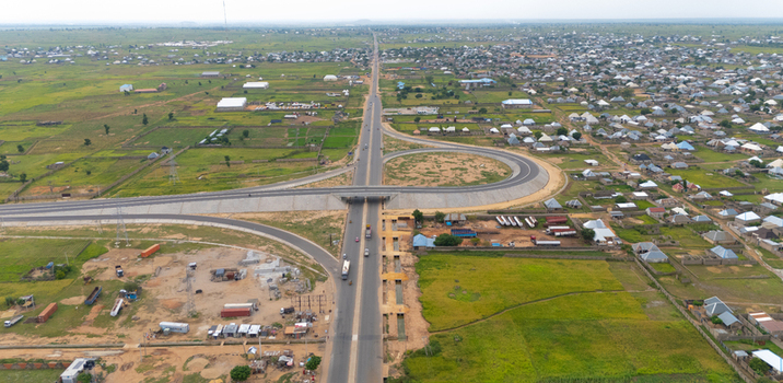 Aerial view of a modern highway interchange and flyover connecting roads through the outskirts of the city surrounded by residential areas and agricultural fields in Yola Adamawa Nigeria. Aerial view of a modern highway interchange and flyover connecting roads through the outskirts of the city surrounded by residential areas and agricultural fields in Yola Adamawa Nigeria.