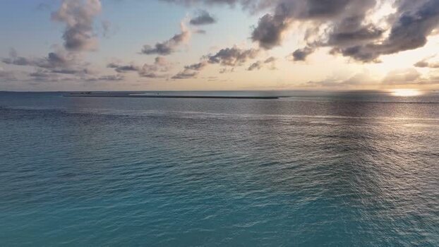 Aerial view of the turquoise ocean and sandbar at sunset Maldives. Aerial view of the turquoise ocean and sandbar at sunset Maldives.