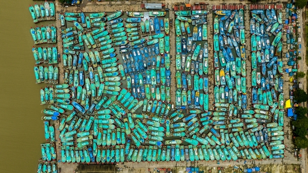 Aerial view of Malpe Fishing Harbour filled with numerous colorful fishing boats docked in rows in the water showcasing the vibrant maritime activity in Udupi Karnataka India. Aerial view of Malpe Fishing Harbour filled with numerous colorful fishing boats docked in rows in the water showcasing the vibrant maritime activity in Udupi Karnataka India.