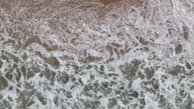 Aerial view of ocean waves crashing on Copacabana Beach Brazil.