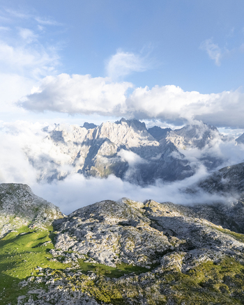 Aerial view of dramatic peaks piercing through the swirling clouds capturing the rugged terrain and the ethereal beauty of the landscape Picos de Europa Asturias Spain. Aerial view of dramatic peaks piercing through the swirling clouds capturing the rugged terrain and the ethereal beauty of the landscape Picos de Europa Asturias Spain.