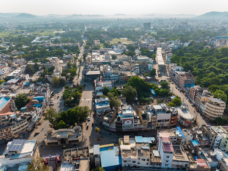 Aerial view of the historic city of Udaipur with its dense urban layout traditional buildings winding streets and surrounding lush greenery in Udaipur Rajasthan India.