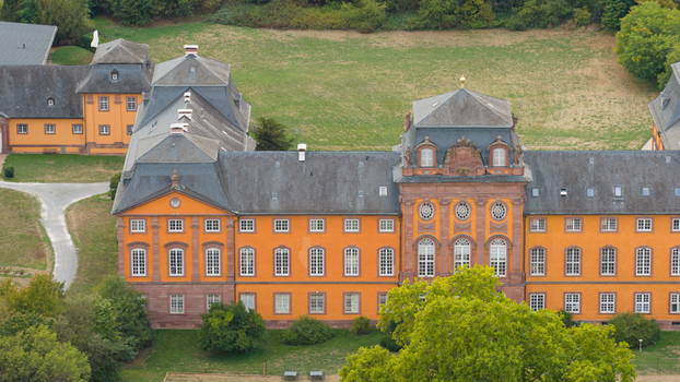 Aerial view of Chateauform Schloss Lowenstein with its distinctive orange facade slate roof and surrounding greenery in Kleinheubach Bayern Germany. Aerial view of Chateauform Schloss Lowenstein with its distinctive orange facade slate roof and surrounding greenery in Kleinheubach Bayern Germany.
