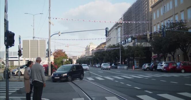 View of a busy street scene with cars and festive bunting in Croatia. View of a busy street scene with cars and festive bunting in Croatia.