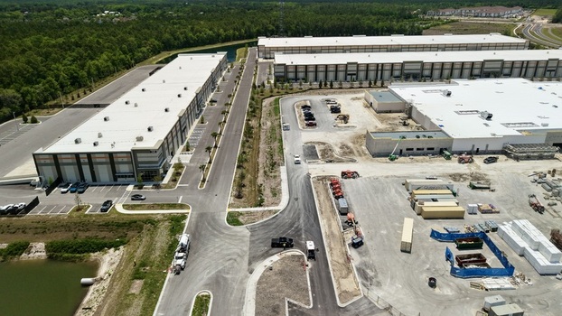 Aerial view of the large warehouse complex and construction site at Saint Johns Parkway and International Golf Parkway with lush forest World Golf Village Florida United States. Aerial view of the large warehouse complex and construction site at Saint Johns Parkway and International Golf Parkway with lush forest World Golf Village Florida United States.