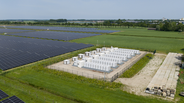 Aerial view of a large solar farm featuring rows of photovoltaic panels and a battery energy storage system in a rural landscape in Wanneperveen Overijssel Netherlands.