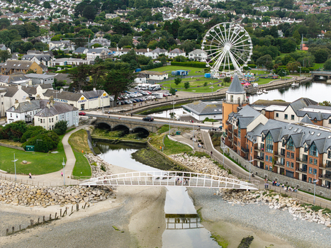 Aerial view of the coastal town featuring a Ferris wheel a pedestrian bridge over a stream and surrounding buildings in Newcastle Northern Ireland United Kingdom. Aerial view of the coastal town featuring a Ferris wheel a pedestrian bridge over a stream and surrounding buildings in Newcastle Northern Ireland United Kingdom.
