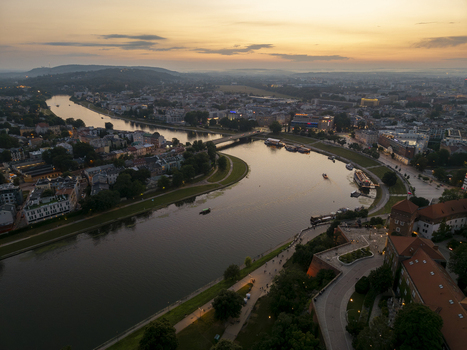 Aerial view of Wawel Royal Castle overlooking the Vistula River at sunset with the historic city skyline and bridges in Krakow Lesser Poland Voivode Poland. Aerial view of Wawel Royal Castle overlooking the Vistula River at sunset with the historic city skyline and bridges in Krakow Lesser Poland Voivode Poland.