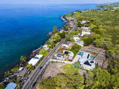 Aerial view of the Kahalu u Beach Park coastline featuring Ali i Drive residential houses with solar panels and turquoise ocean waters in Kailua Kona Hawaii United States. Aerial view of the Kahalu u Beach Park coastline featuring Ali i Drive residential houses with solar panels and turquoise ocean waters in Kailua Kona Hawaii United States.