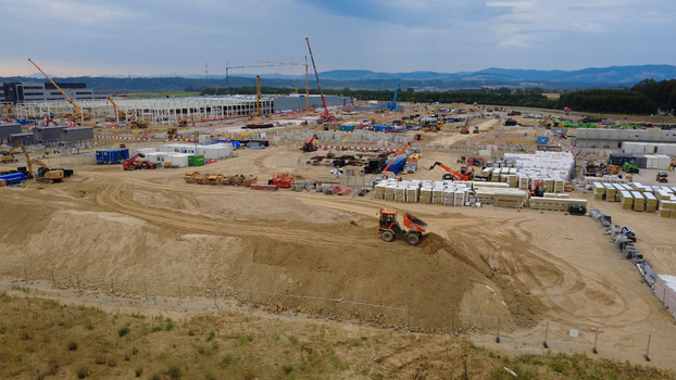 Aerial view of a large data center construction site with heavy machinery cranes and building materials under early morning light in Kronstorf Upper Austria Austria.