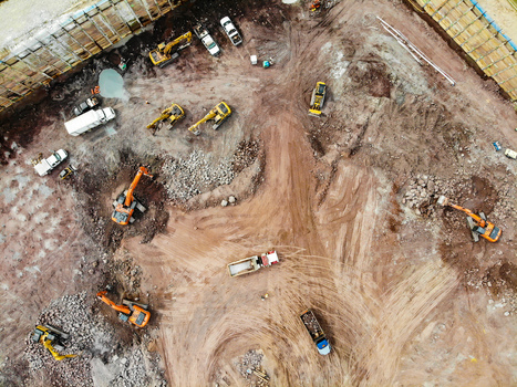 Reston Virginia United States 12 March 2019 Aerial view of a construction site featuring multiple excavators dump trucks and piles of earth and rock. Reston Virginia United States 12 March 2019 Aerial view of a construction site featuring multiple excavators dump trucks and piles of earth and rock.