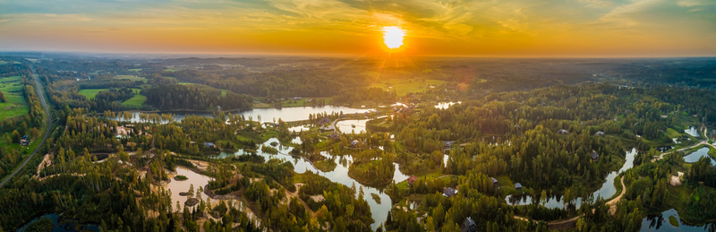 Aerial view of a serene landscape featuring winding waterways numerous small lakes and dense forests illuminated by the warm glow of a sunset Latvia. Aerial view of a serene landscape featuring winding waterways numerous small lakes and dense forests illuminated by the warm glow of a sunset Latvia.