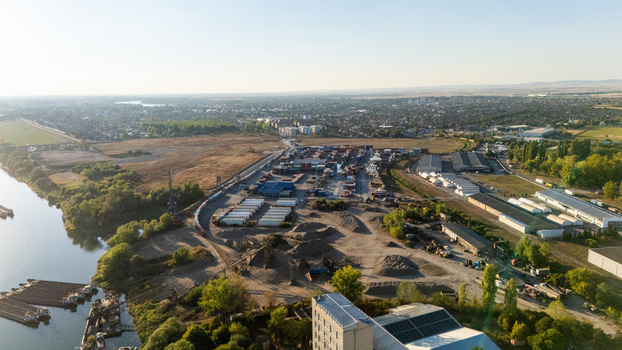 Sremska Mitrovica Serbia 16 September 2026 Aerial view of the industrial port area along the Sava River featuring shipping containers warehouses and surrounding greenery. Sremska Mitrovica Serbia 16 September 2026 Aerial view of the industrial port area along the Sava River featuring shipping containers warehouses and surrounding greenery.